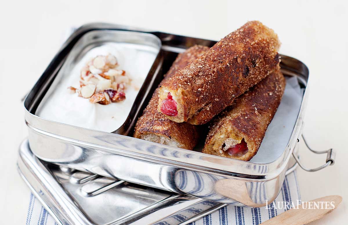 strawberry french toast roll ups in a tin lunch box with yogurt on the side