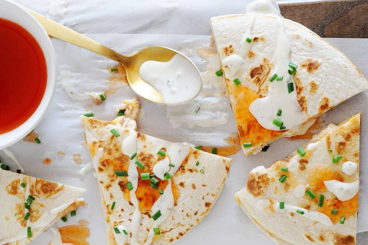 overhead view of sliced quesadillas with Ranch and Buffalo sauce