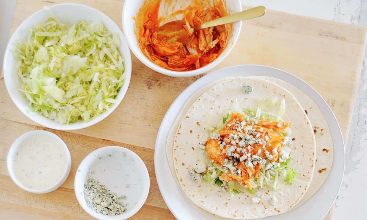 bowls with Buffalo chicken, shredded lettuce, Ranch, Blue cheese crumbles, and tortillas topped with these ingredients