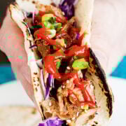a person holding an Asian pork rib taco