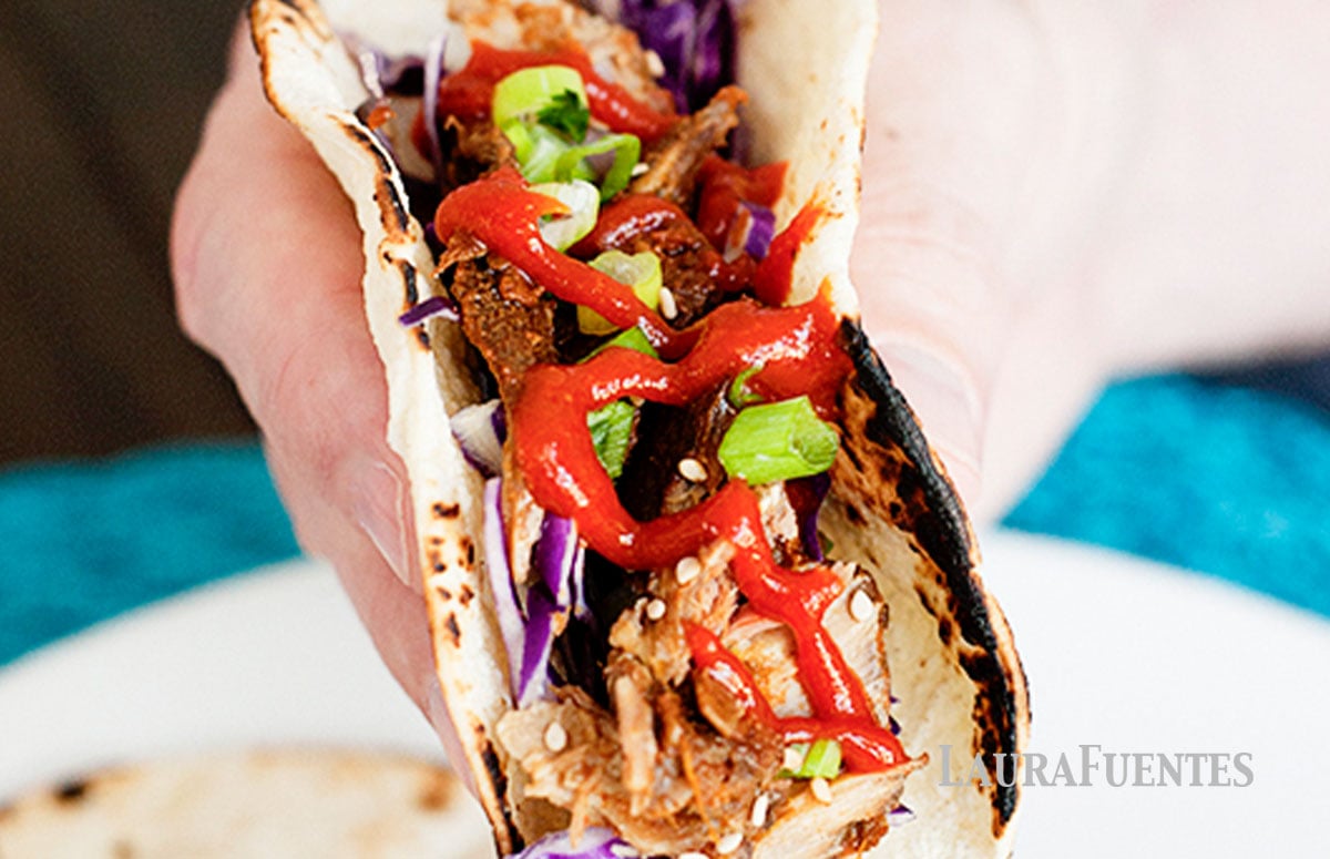 a person holding an Asian pork rib taco