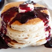 stack of pancakes topped with blueberry syrup