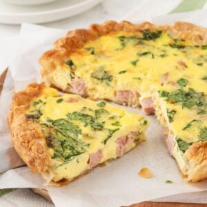 side view of a slice of quiche made with puff pastry with spinach, ham, and cheese