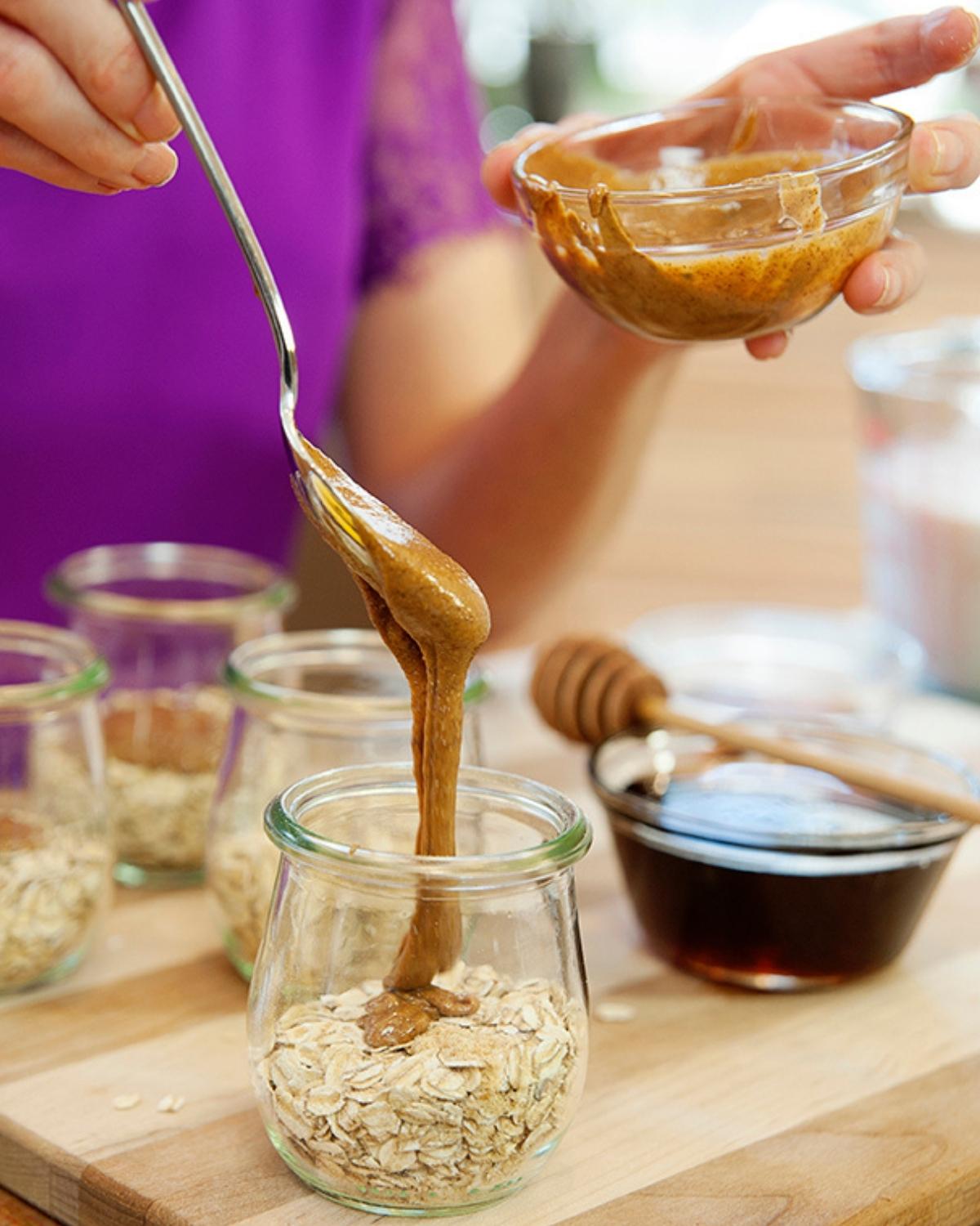 adding almond butter to overnight oats jars