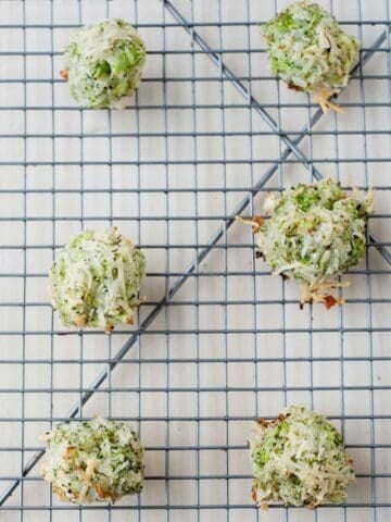 closeup of six cheesy broccoli tots on a cooling rack