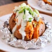 baked sweet potato topped with ranch, chicken, and green onions