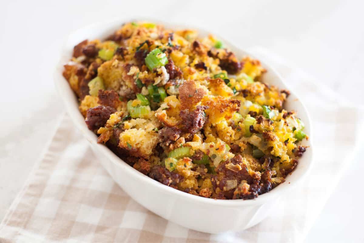 front view of cornbread dressing with sausage in a white baking dish