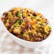 close up view of cornbread dressing with sausage inside a white baking dish