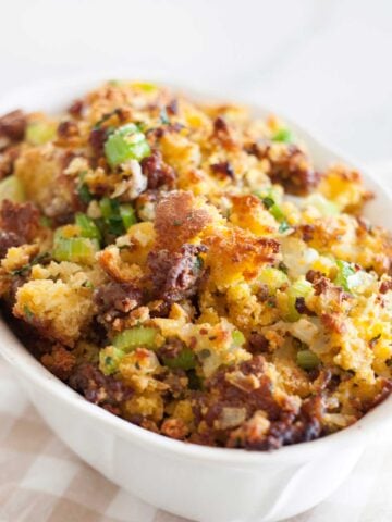 close up view of cornbread dressing with sausage inside a white baking dish