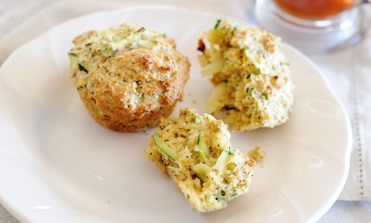 two lemon zucchini muffins on a plate