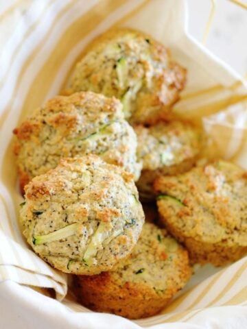 a small basket of lemon zucchini muffins with poppy seeds
