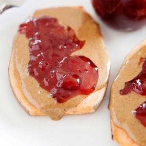 image: PB & J Sweet Potato Toasts on a plate with a jar of strawberry jelly