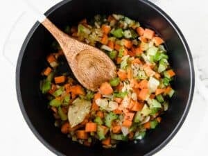onion, garlic, carrots, and celery being sauteéd in a pot