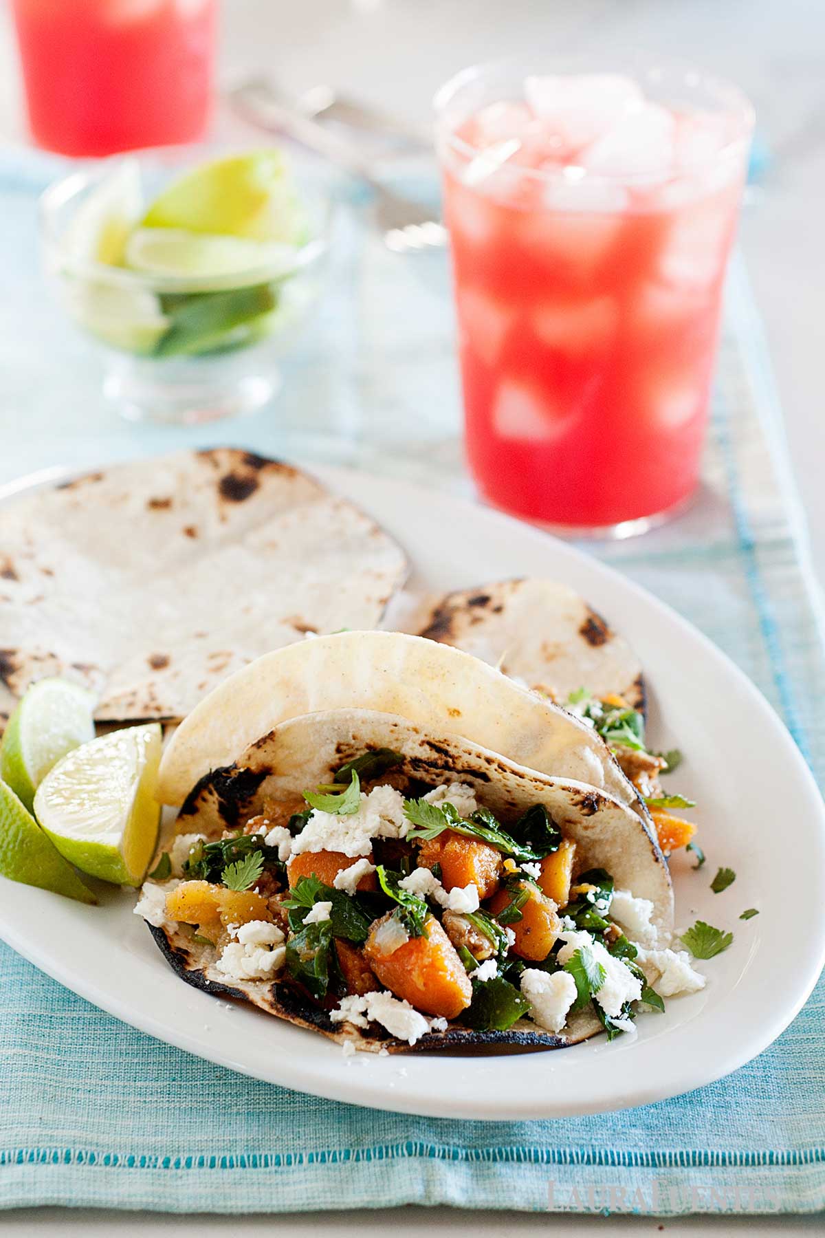 butternut squash tacos on a plate and two drinks behind