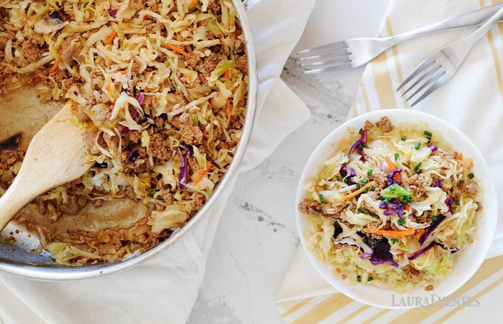 Image: One white bowl of egg roll ingredients, next to full skillet of the same.