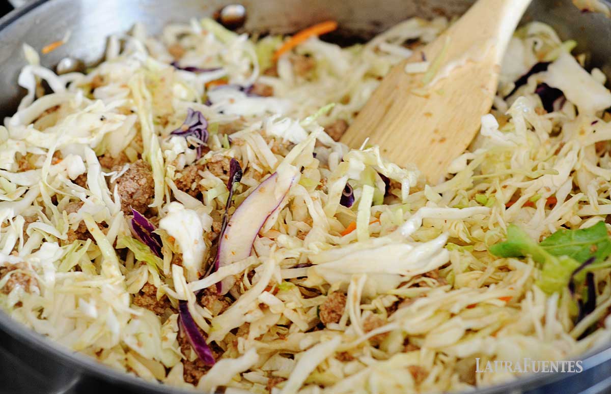 image: Step two recipe instructions for egg roll in a bowl, cooking all ingredients together in a skillet on the stove.