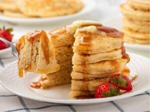 gluten-free pancakes stacked and a fork grabbing a serving