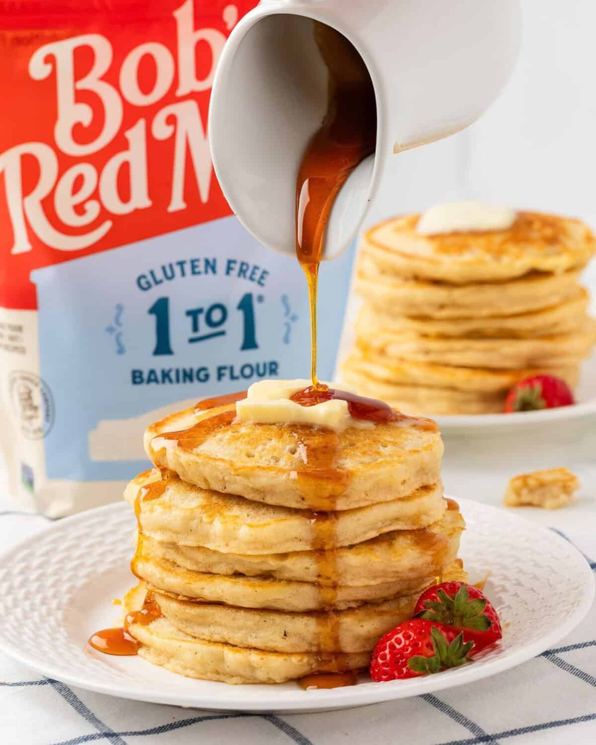 a stack of gluten-free pancakes being drizzle with syrup