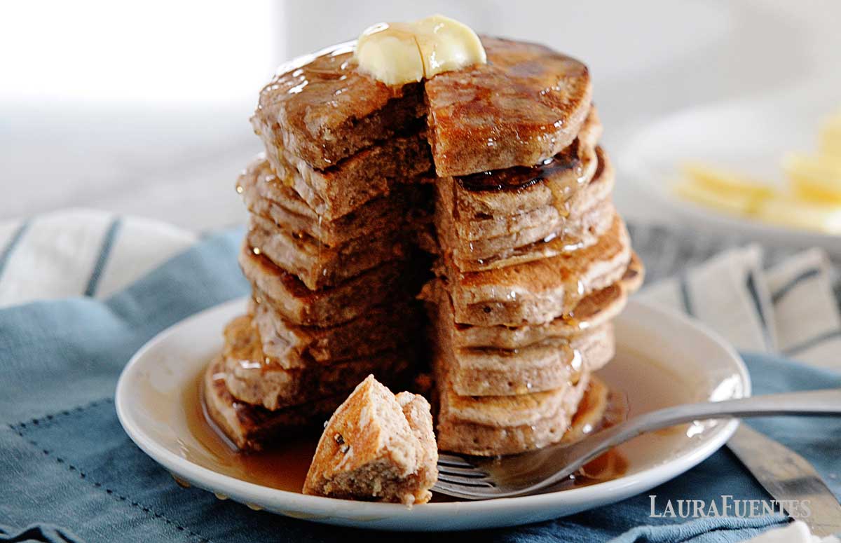 large stack of cinnamon pancakes with small triangle cut out