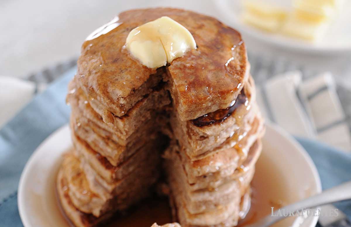 large stack of cinnamon pancakes with small triangle cut out