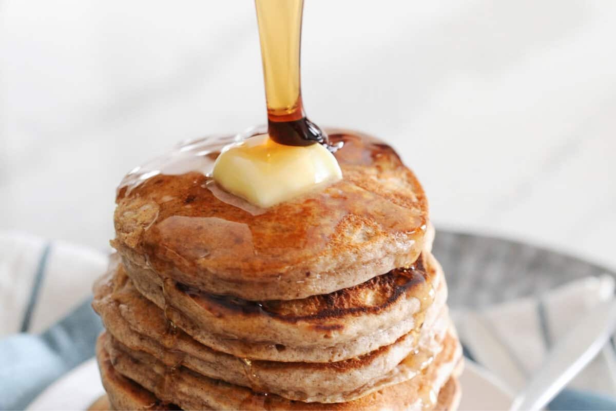 cinnamon syrup being poured over pancakes