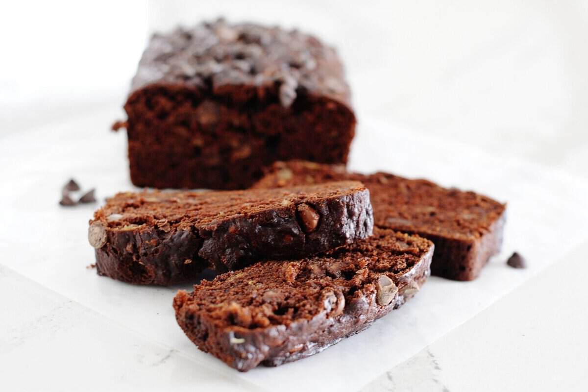 loaf of double chocolate banana bread with three slices cut out