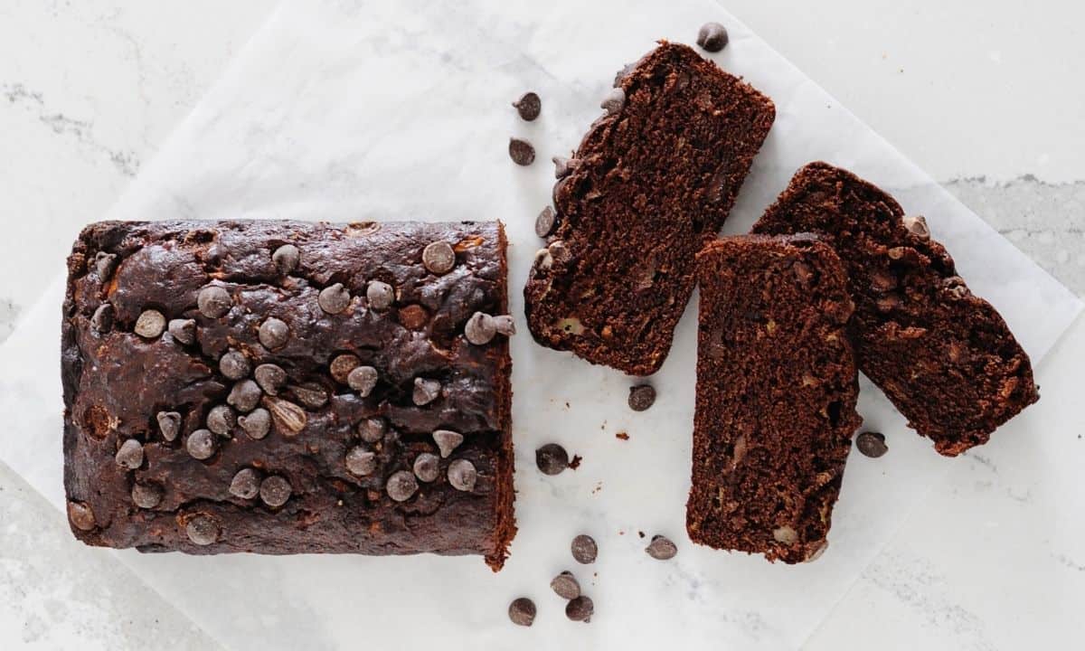 overhead view of a loaf of double chocolate banana bread with three slices cut out