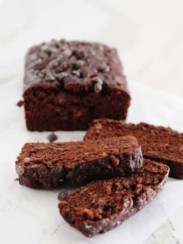 loaf of double chocolate banana bread with three slices cut out