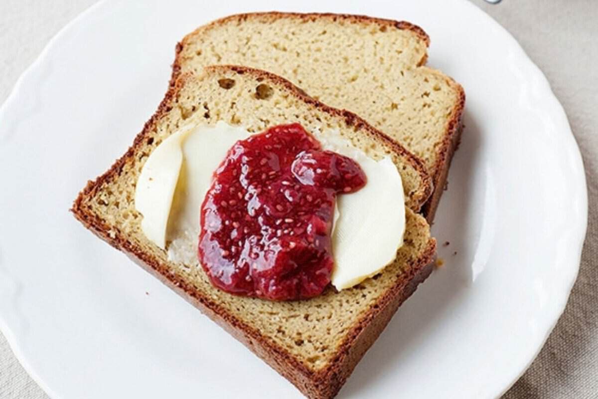 two slices of paleo bread with butter and strawberry jam in a plate