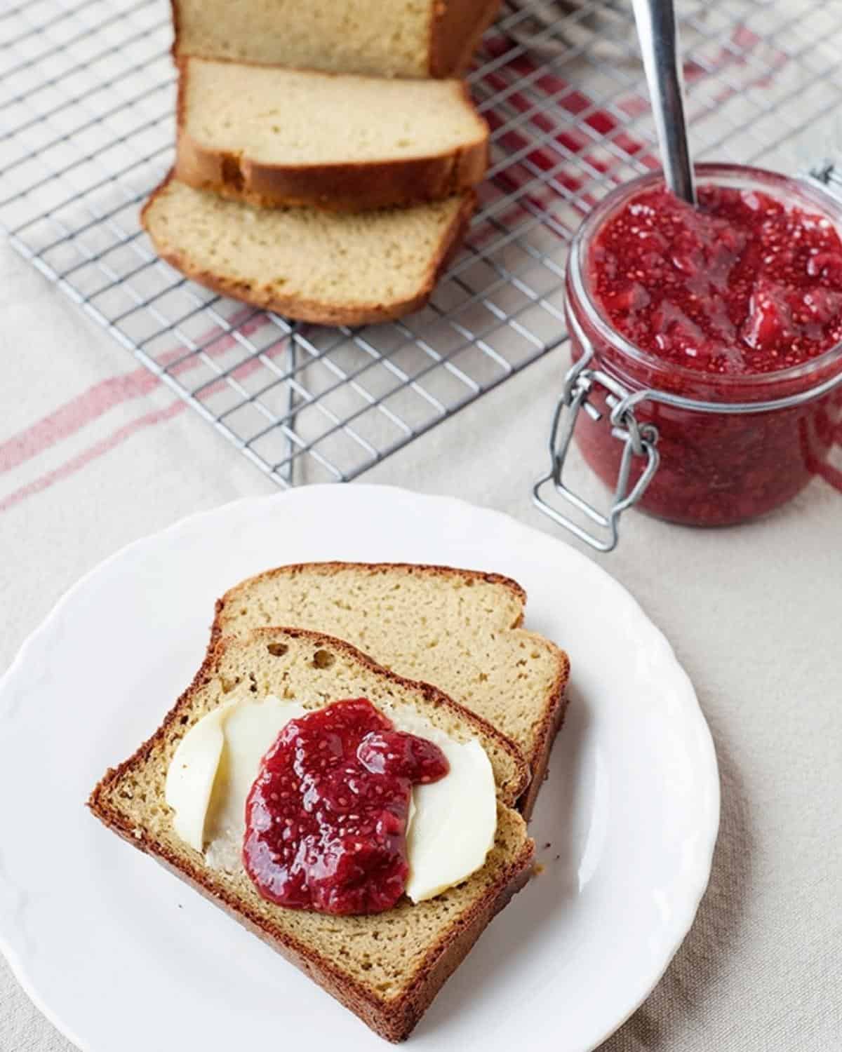 two slices of paleo bread with butter and strawberry jam in a plate