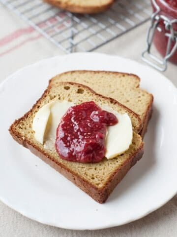 two slices of paleo bread with butter and strawberry jam in a plate