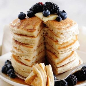 a stack of cassava flour pancakes on a white plate with blueberries on top
