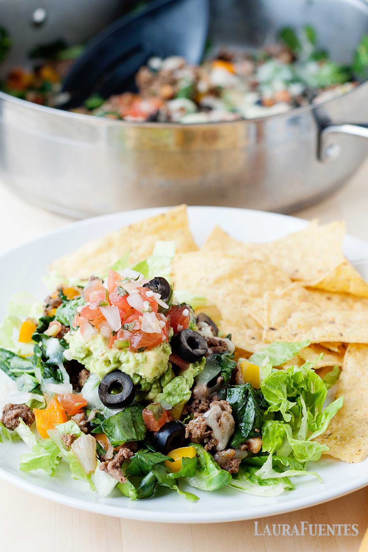 taco skillet with lettuce and chips on a plate