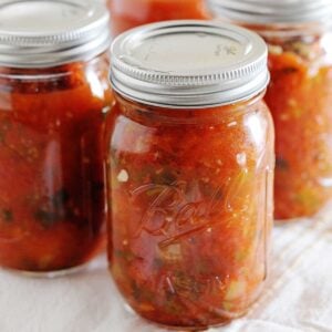 image: Four full jars of canned red salsa