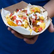 two cauliflower tacos in a paper plate