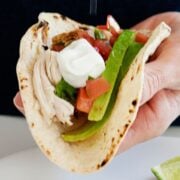 Mexican chicken taco topped with sour cream and tomatoes