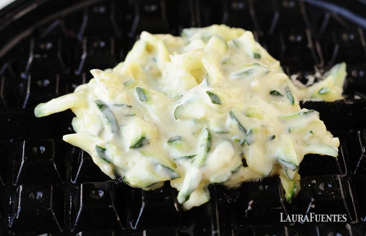 zucchini parmesan waffle batter on a waffle iron