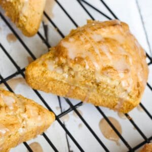 paleo scone with glaze on a cooling rack