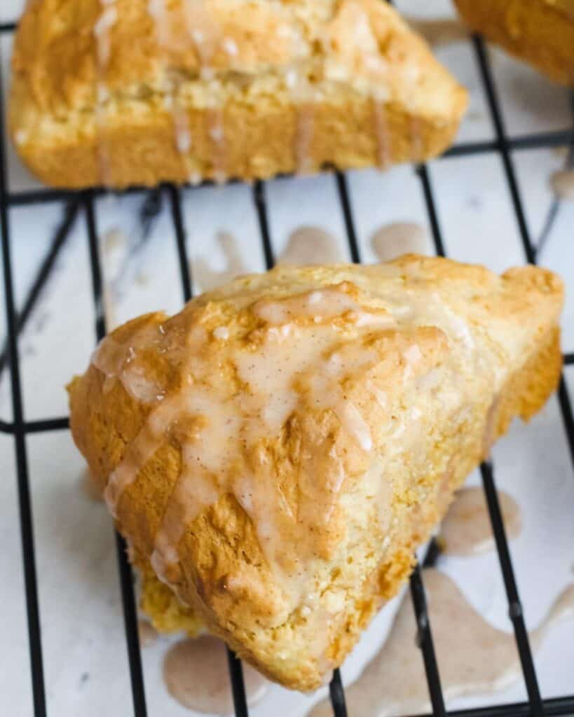 paleo scone with glaze on a cooling rack