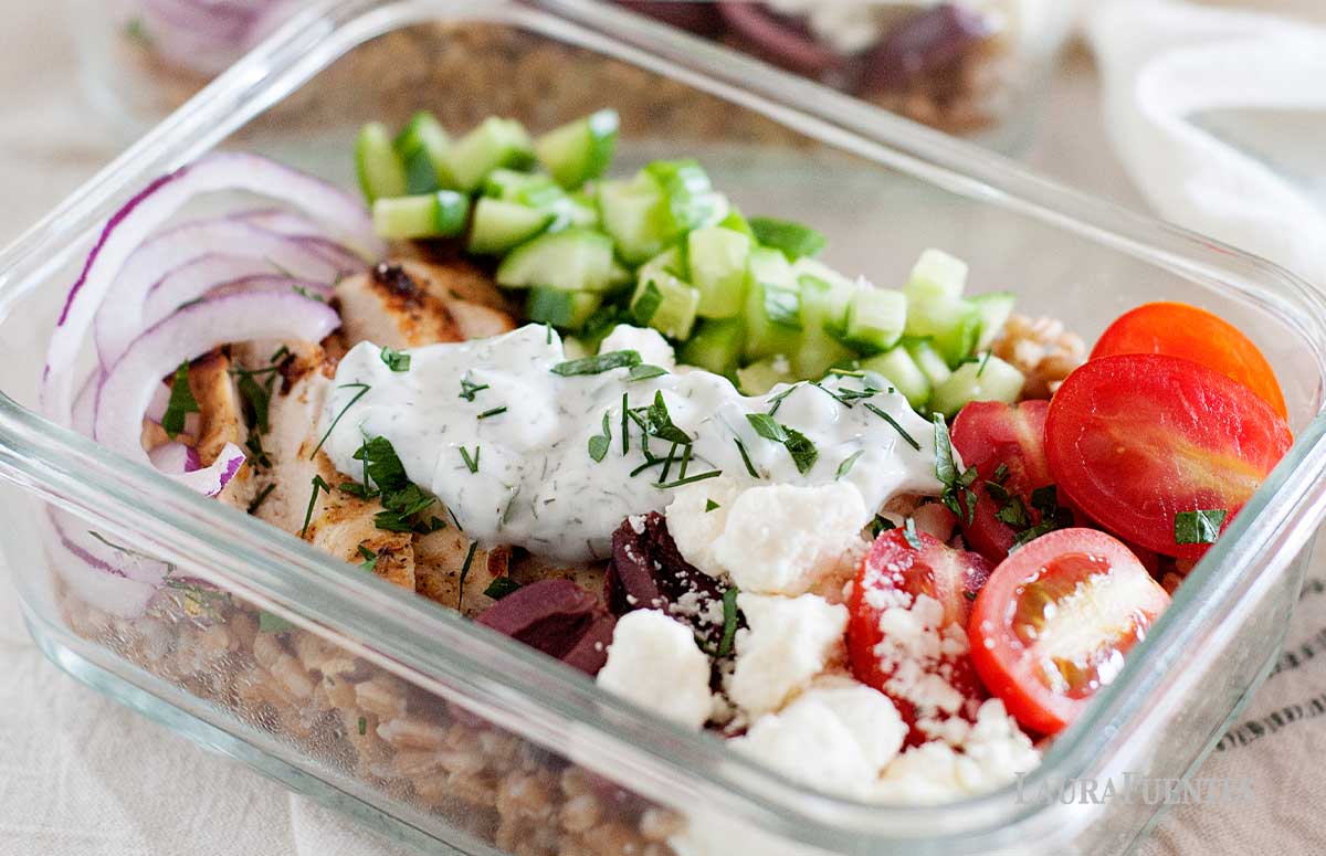 a glass lunch container with mediterranean chicken and farro