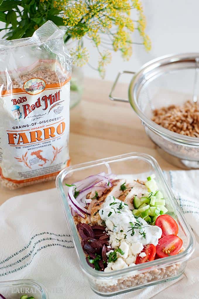 chicken farro recipe preppe in glass container with bag of extra farro in background
