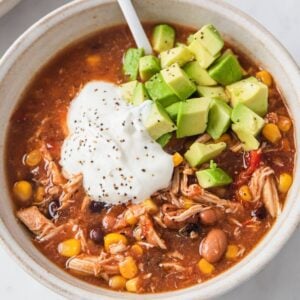 top view of a chicken taco soup topped sour cream and avocado