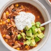 top view of a turkey taco soup topped sour cream and avocado