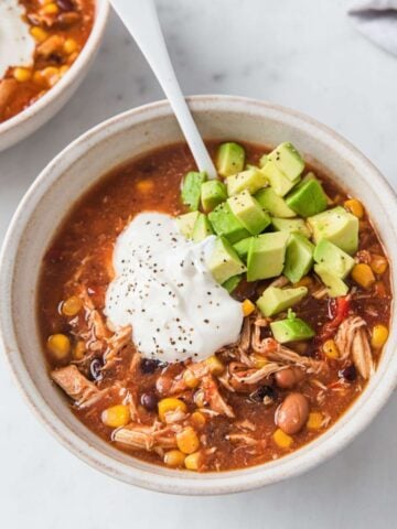 top view of a turkey taco soup topped sour cream and avocado