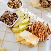 apple slices, popcorn, cheese and pretzel sticks on a platter