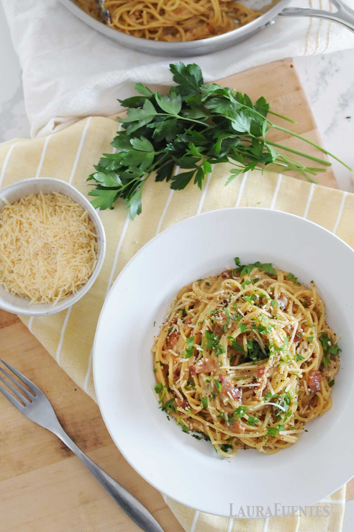 overhead view of spaghetti carbonara in a bowl with toppings
