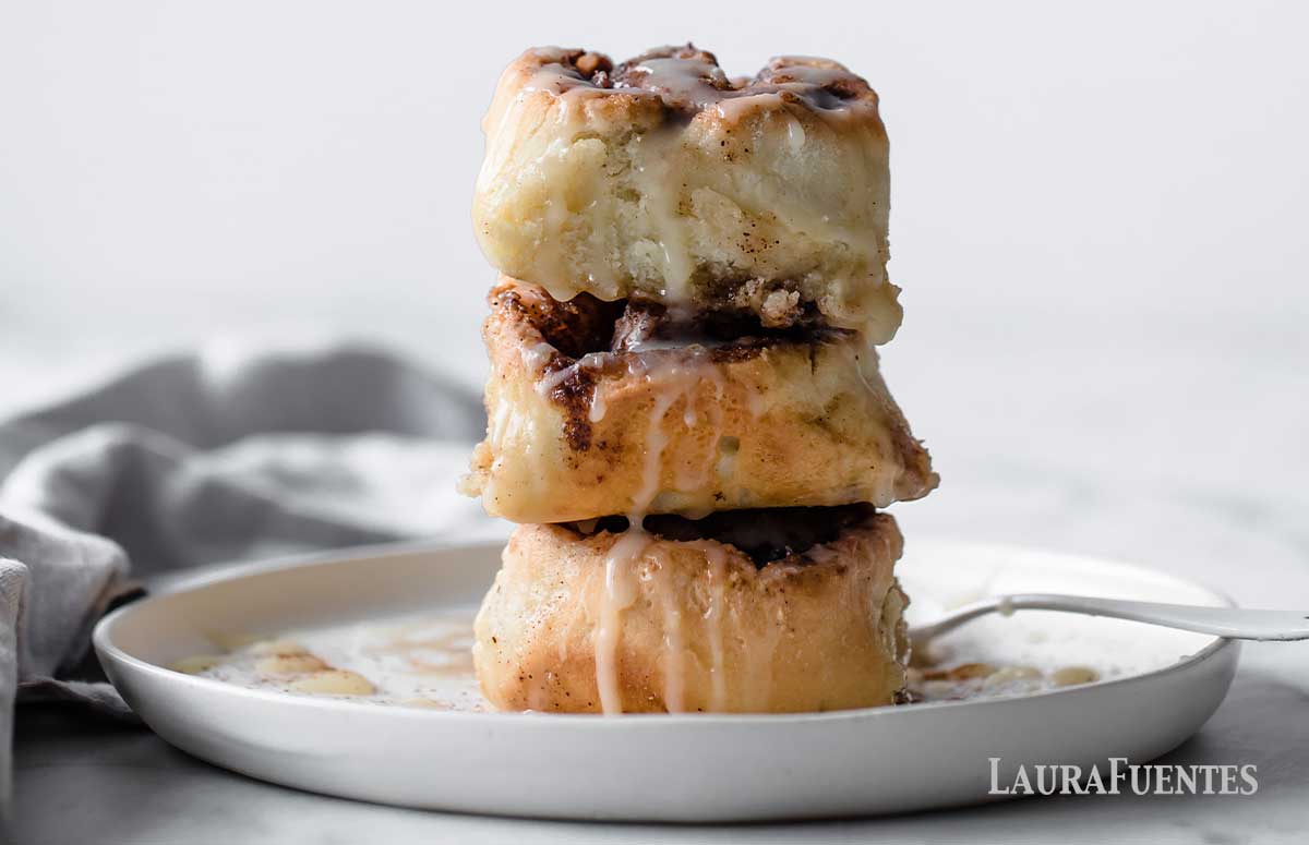 image: three gluten free cinnamon rolls on top of each other on a plate