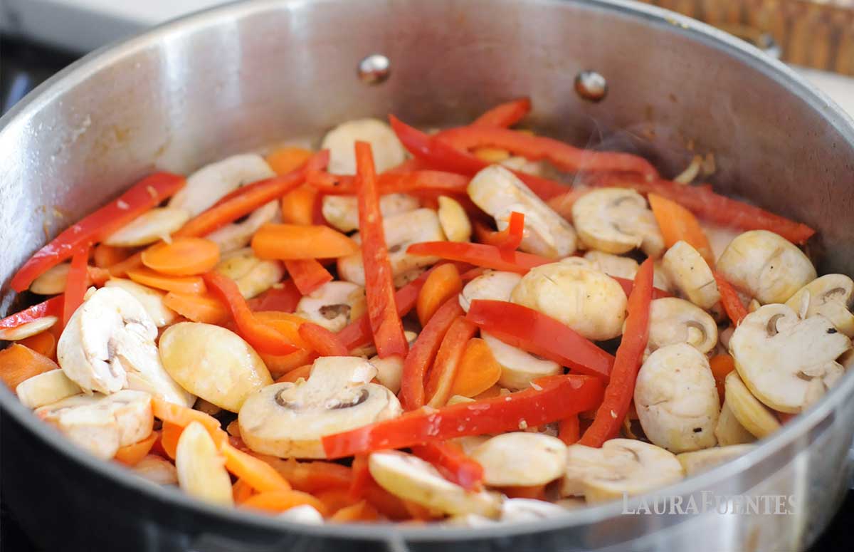 sliced mushrooms, red pepper and carrots in a skillet