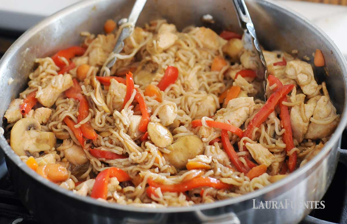 sliced mushrooms, red pepper and chicken in a skillet with thin ramen noodles