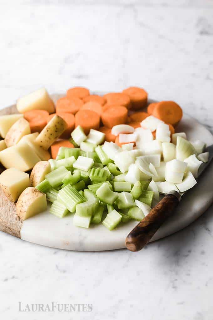 image: chopped onions, potatoes, carrots and celery